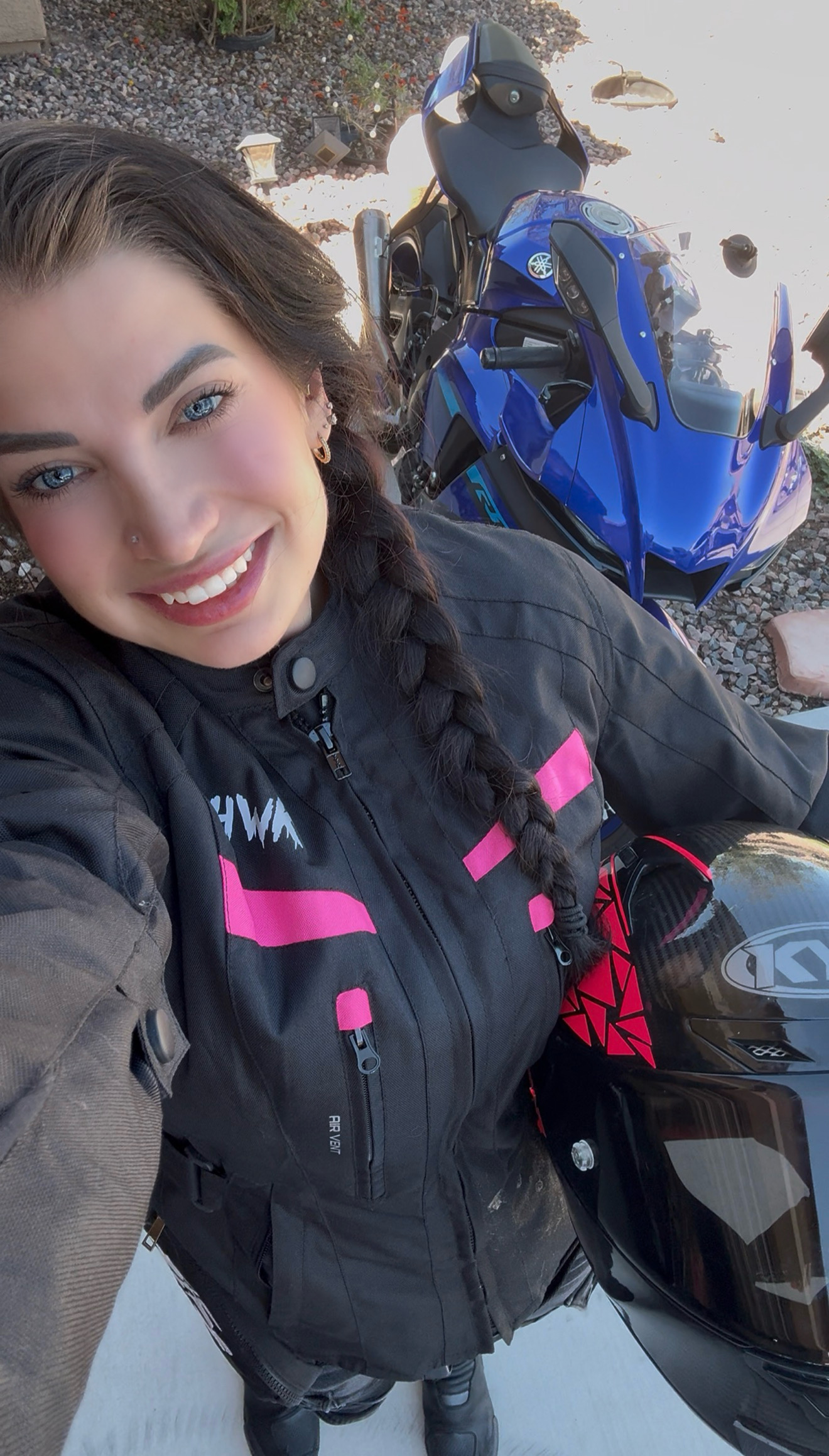 Slick smiling beside her blue Yamaha, the same photo featured on the billboard